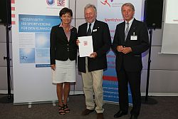 Dr. Arno Grau, Umweltbeauftragter des WYC (Mitte), freut sich über die Urkunde. Links die hessische Umweltministerin Lucia Puttrich (CDU), rechts Rolf Hocke, Vizepräsident Landessportbund Hessen