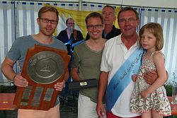 Die Sieger des Blauen Bandes der Segelsport-Gemeinschaft Edersee Sven Dömges, Björn und Winfried Geisler mit Enkelkind Vilja (v.l.n.r.). Im Hintergrund Vereinsvorsitzender Paul Völlmecke.