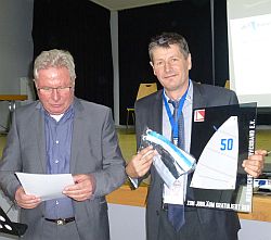 Präsident Klaus-Dieter Lachmann (li) überreicht Dr. Andreas Lauterbach ein Jubiläumsgeschenk.